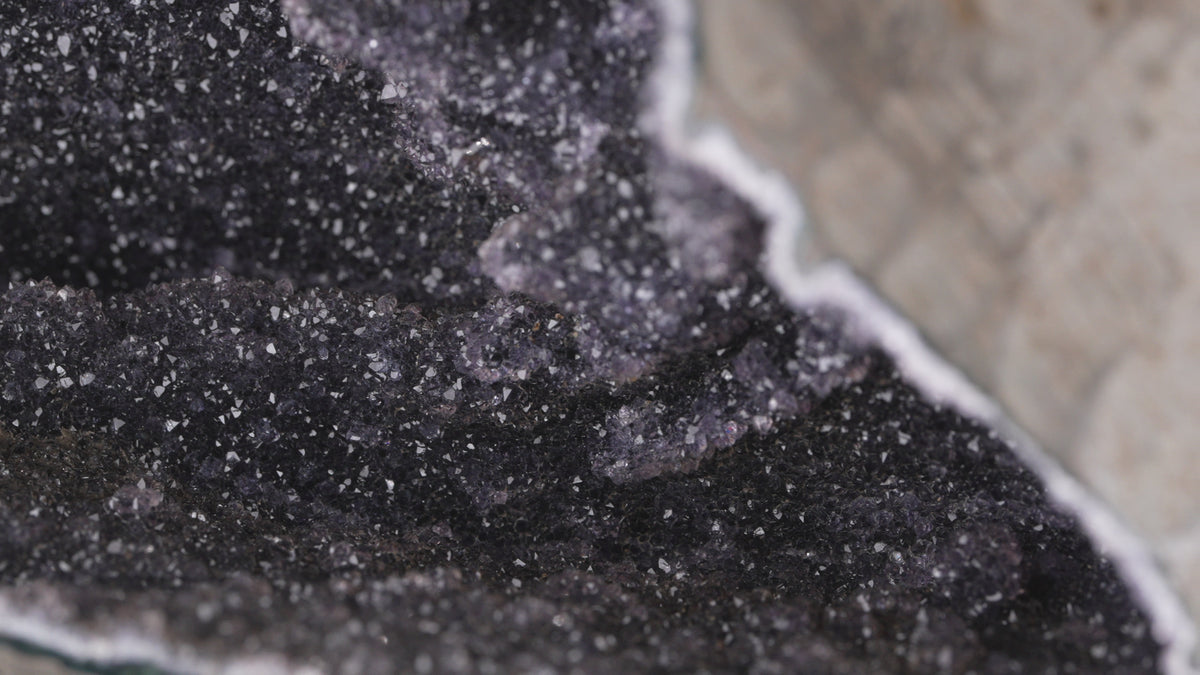,,Schwarzer'' Amethyst Druse auf Stand mit Funkelnde Höhle